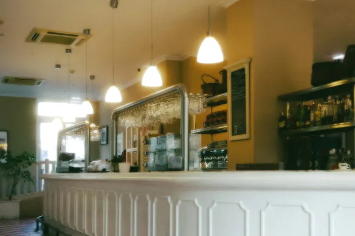Barra de un bar con estantería de botellas
