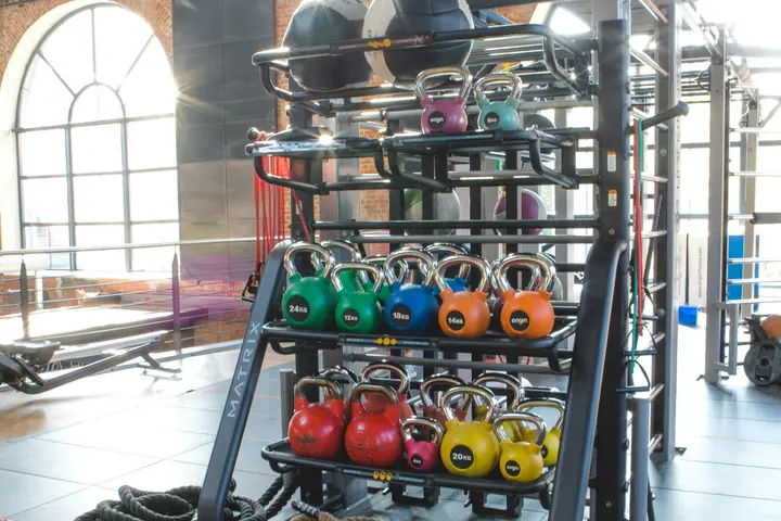 Sala de gimnasio con kettlebells de colores